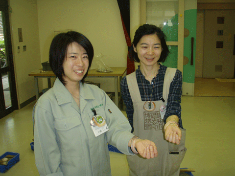 貝輪を試着する博物館の女性スタッフ