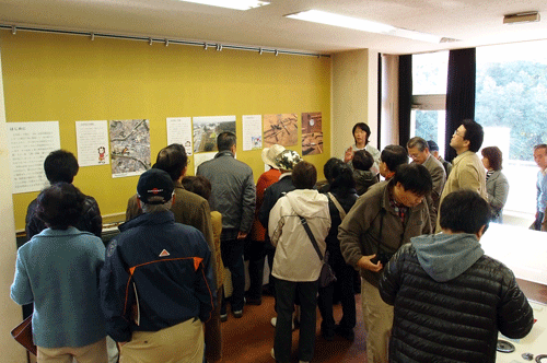 展示解説に聴き入る見学者